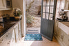Recycled Kingfisher doormat by Atlantic Mats in a kitchen doorway leading to a garden.