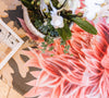 Atlantic Mats recycled rug with a red chrysanthemum design, styled with a potted plant.