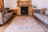 Atlantic Mats Recycled Rug in Gold Rose floral design in a cozy living room with a fireplace