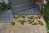 RHS Bloom Coir Collection Autumn Oak doormat with green oak leaf patterns on a stone patio.