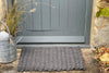 Charcoal Grey Outdoor Rope Doormat by Atlantic Mats in front of a grey door