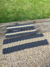 Three Atlantic Mats extra large rope doormats in grey and beige stripes on wooden steps.
