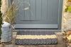 Atlantic Mats Natural Stripe Grey Outdoor Rope Doormat in front of a grey door
