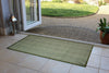 Atlantic Mats recycled plain green runner doormat at an open doorway leading to a patio.
