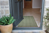 Atlantic Mats recycled plain green runner in an open doorway entryway